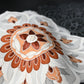 Close-up view of vintage Japanese women's black silk haori with stylised floral motif with embroidery.