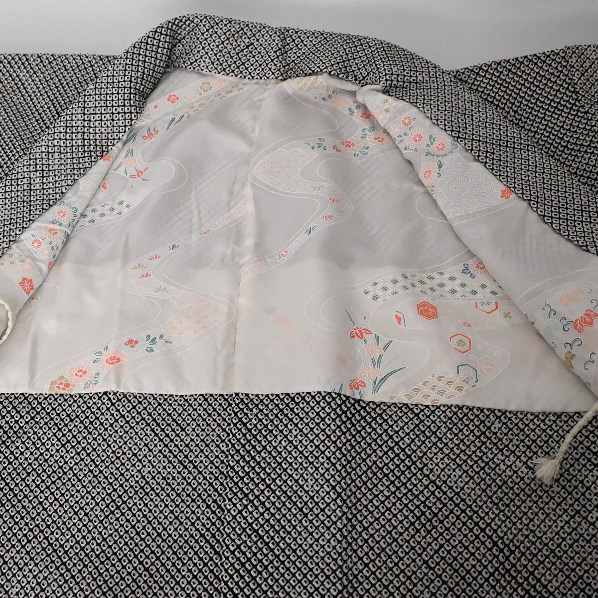 The lining of vintage women's black and white silk haori with all-over kanoko shibori pattern.