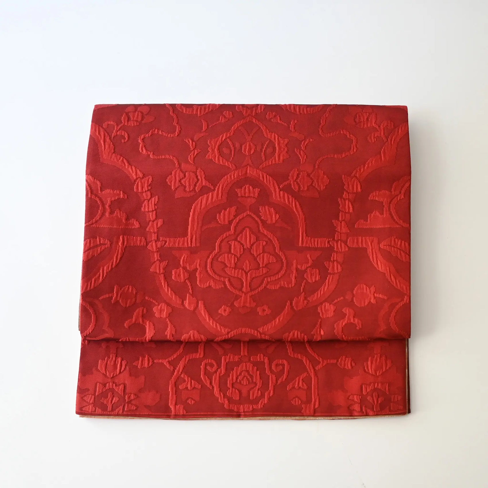 Vintage women's silk Fukure-ori obi with oriental motif in burgundy red and orange.