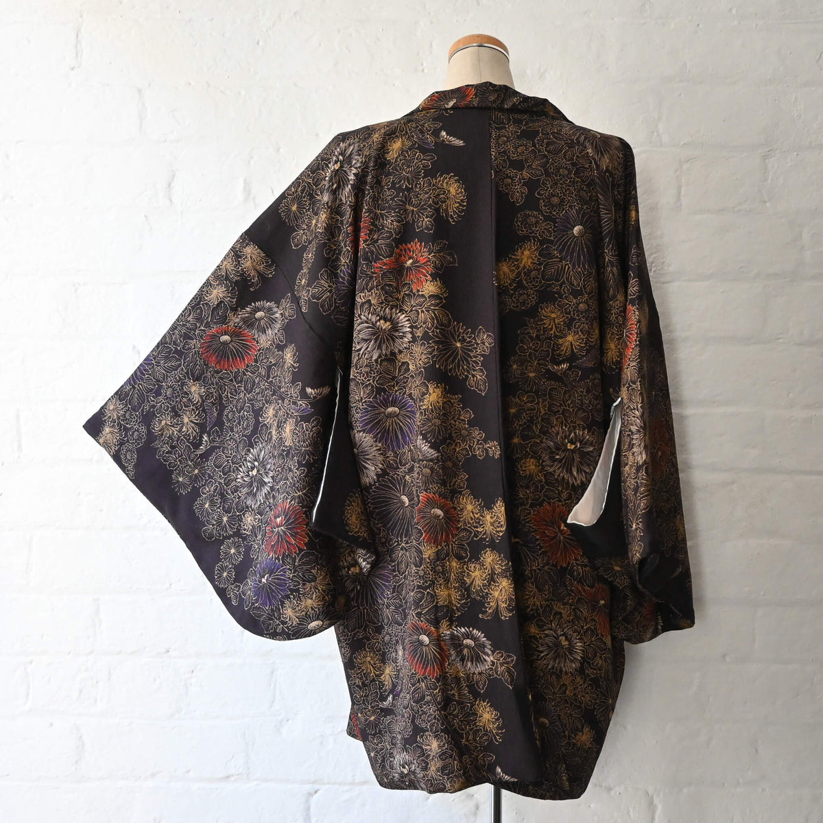 Vintage Japanese women’s haori in dark purple with an all-over chrysanthemum design in gold. Lightweight synthetic fabric.