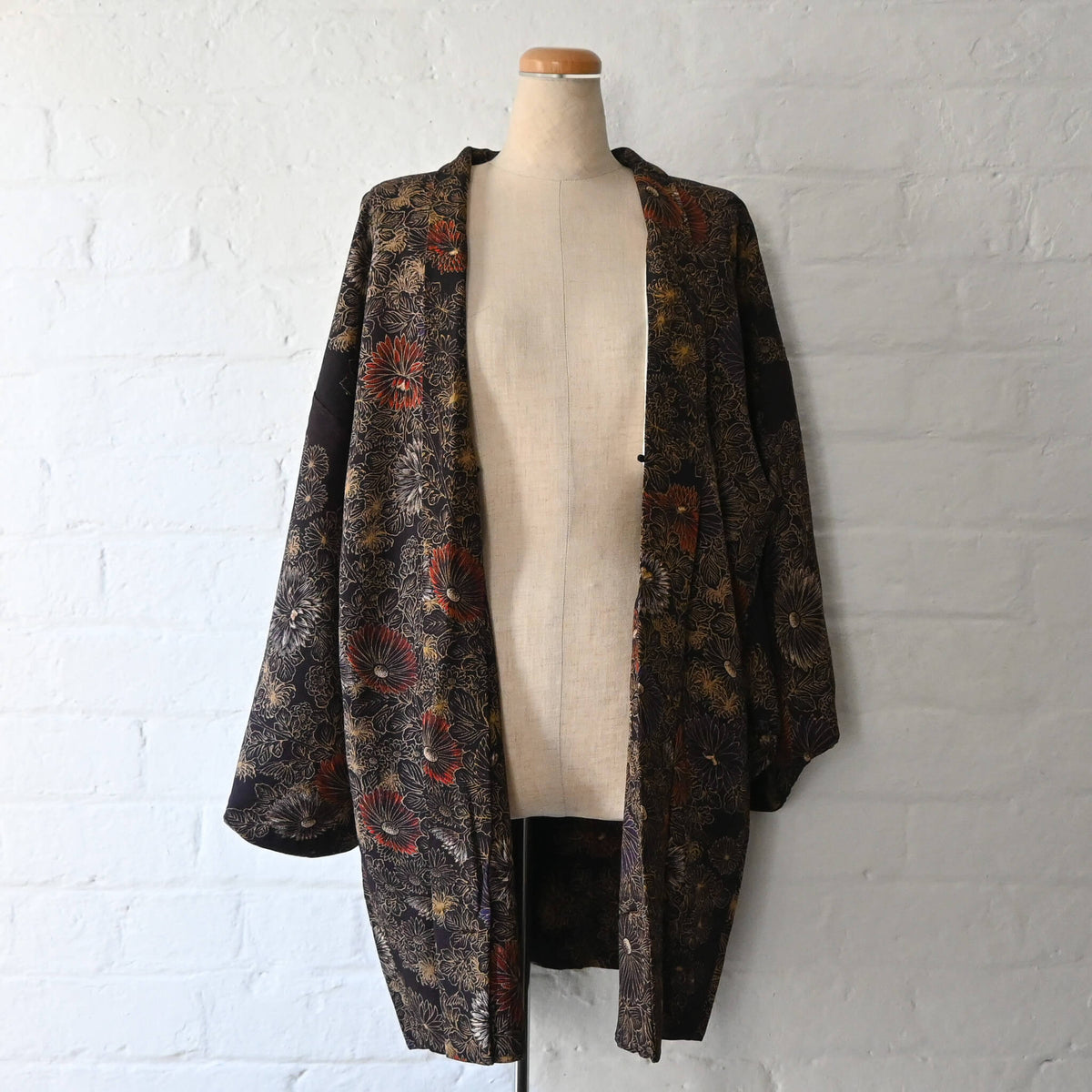 Vintage Japanese women’s haori in dark purple with an all-over chrysanthemum design in gold. Lightweight synthetic fabric.