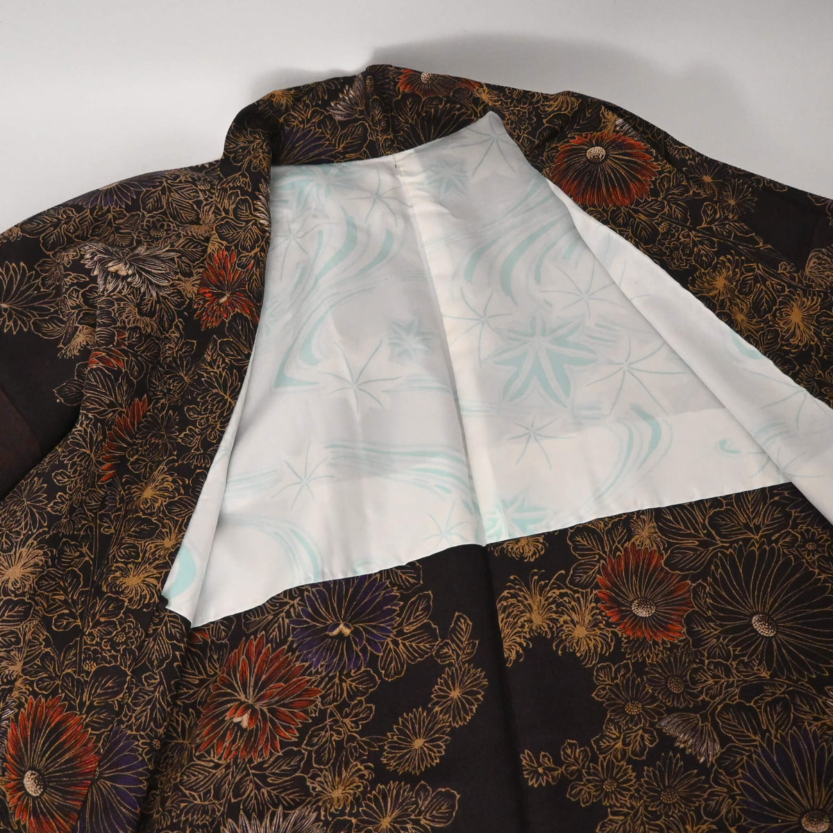 Vintage Japanese women’s haori in dark purple with an all-over chrysanthemum design in gold. Lightweight synthetic fabric.