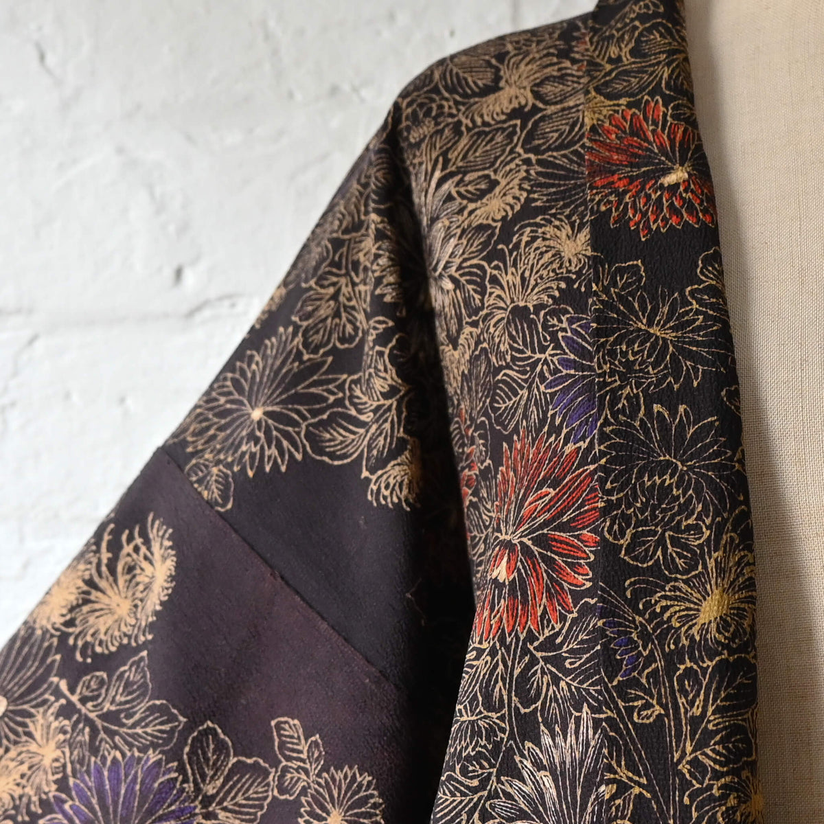 Vintage Japanese women’s haori in dark purple with an all-over chrysanthemum design in gold. Lightweight synthetic fabric.
