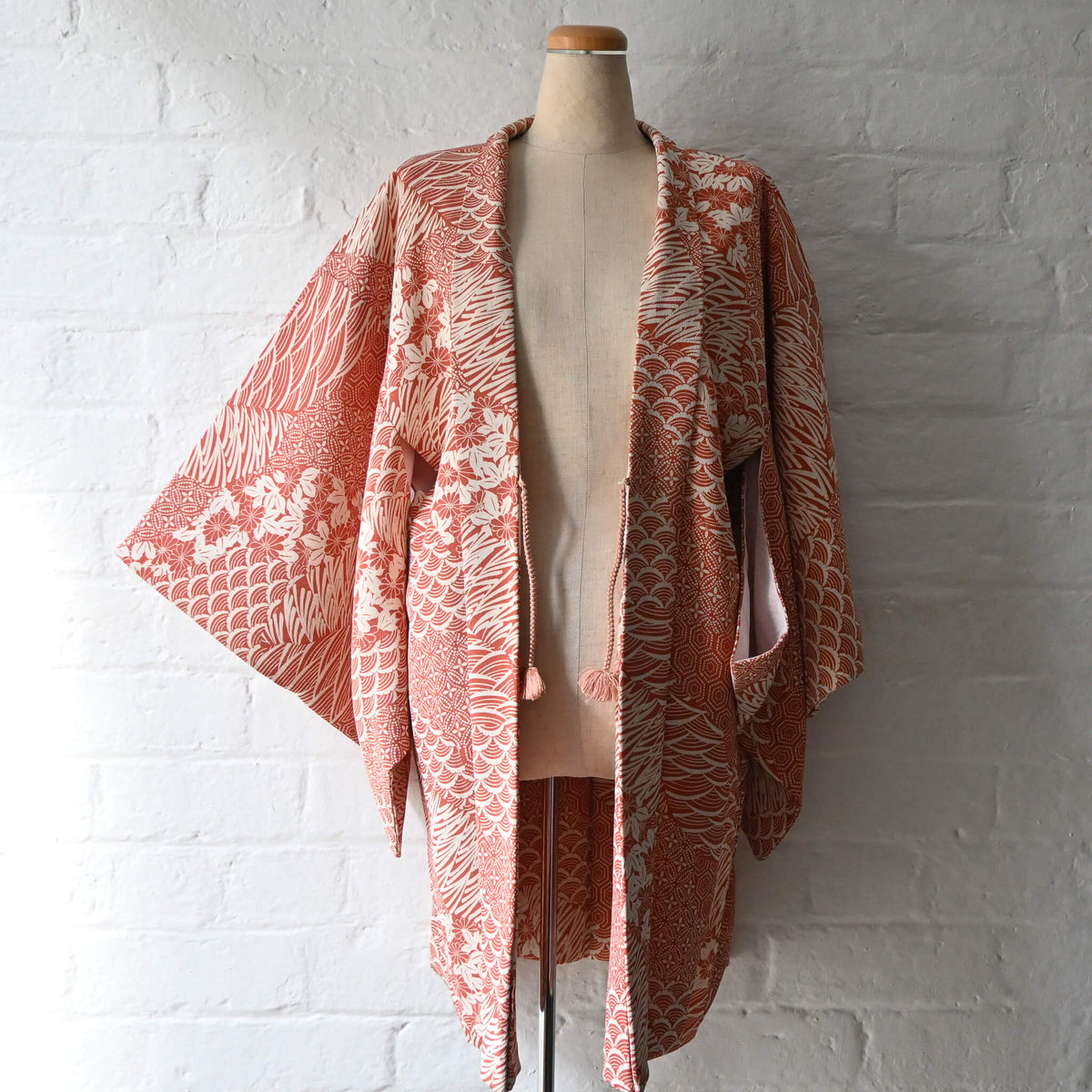 Vintage women's synthetic crepe haori in terracotta and ivory with floral and geometric patterns.