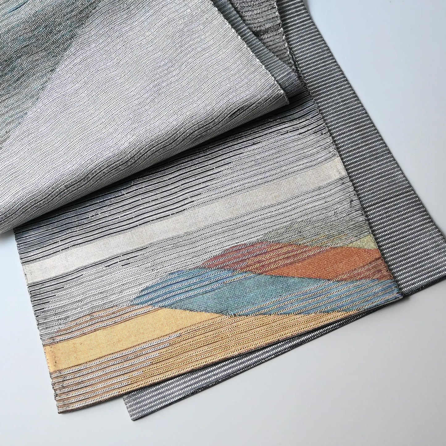 Detailed view of vintage Japanese women's silk metallic Bukuro obi with mountain design.