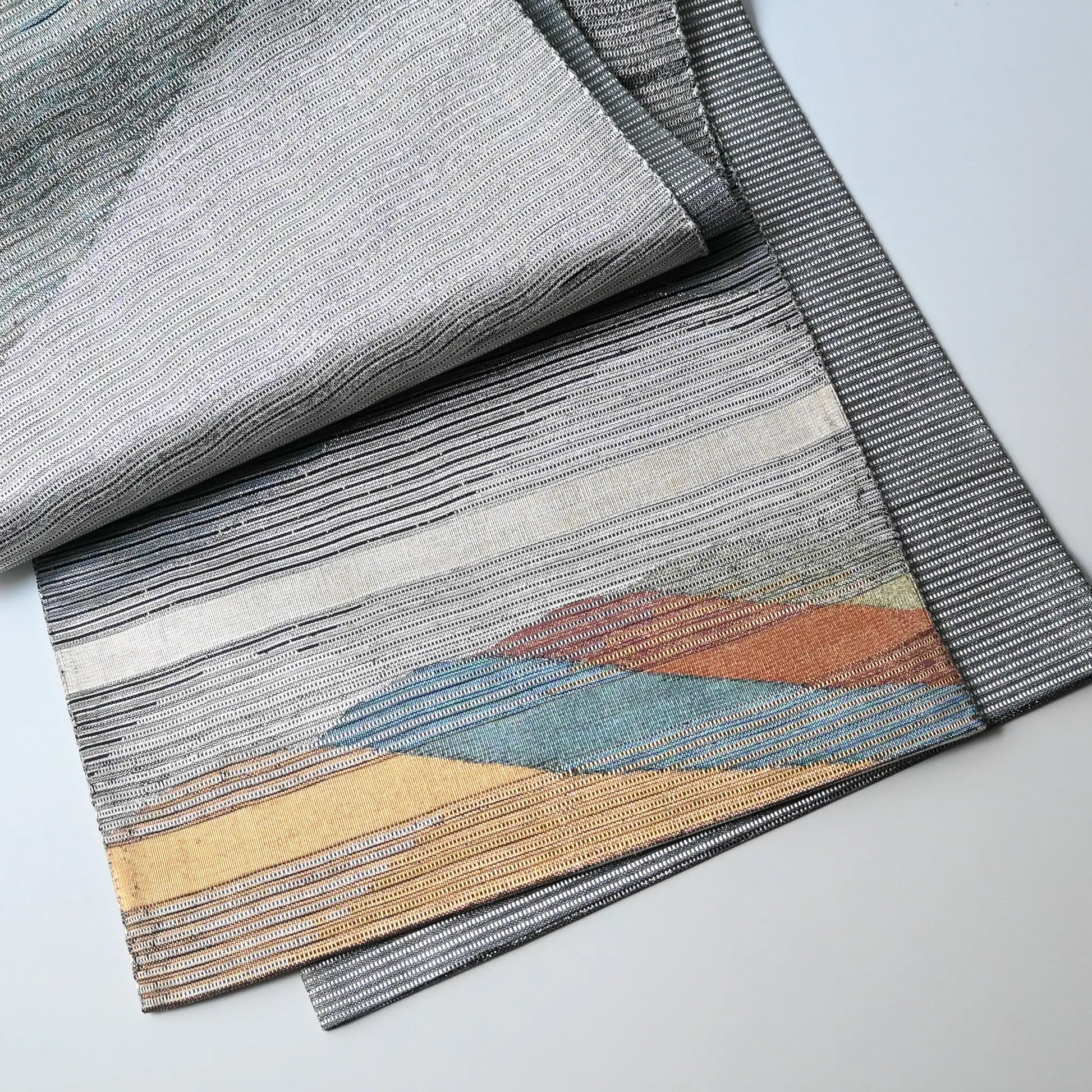Detailed view of vintage Japanese women's silk metallic Bukuro obi with mountain design.