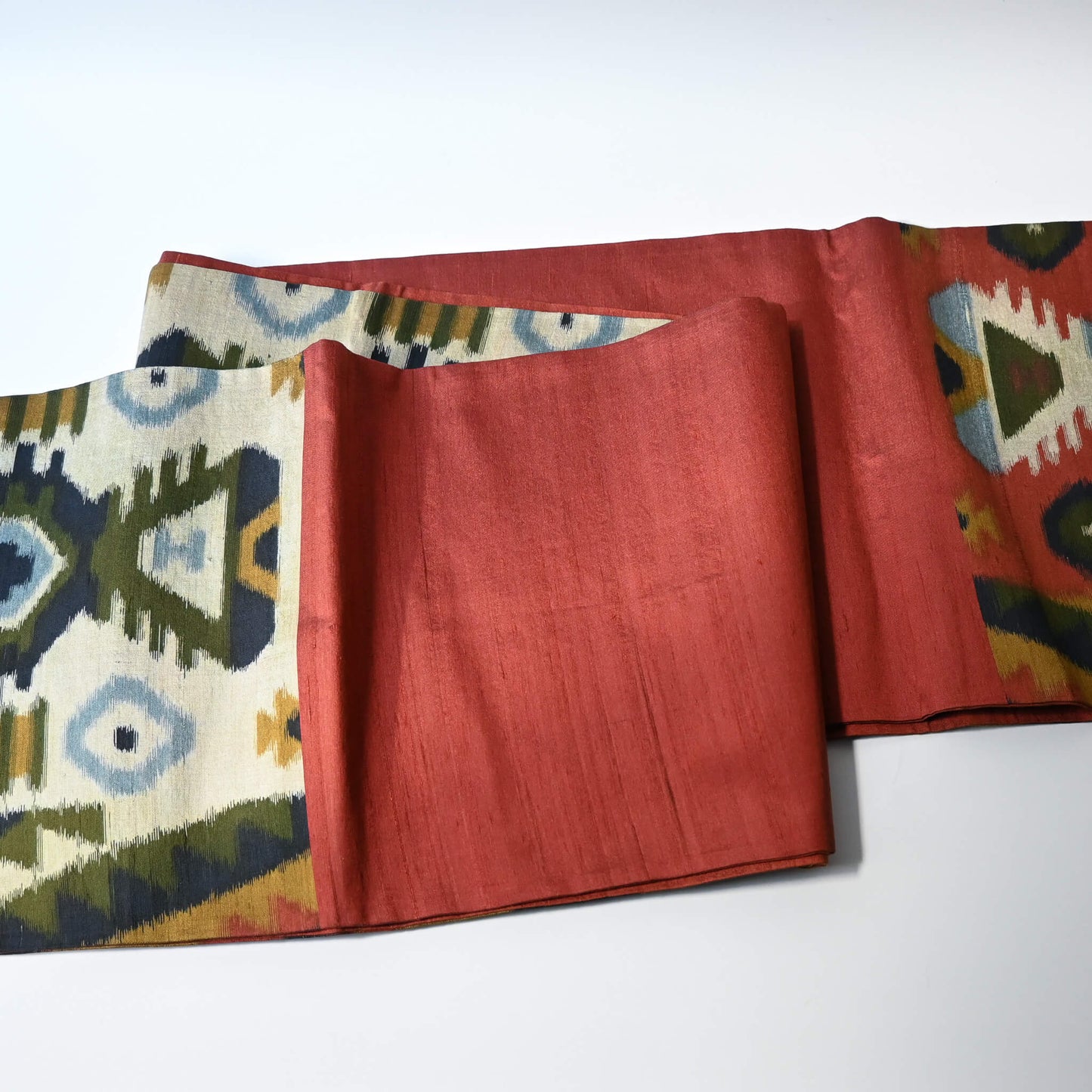 Detailed view of vintage Japanese women's tsumugi silk Fukuro obi with abstract geometric design in rustic orange and green tone.
