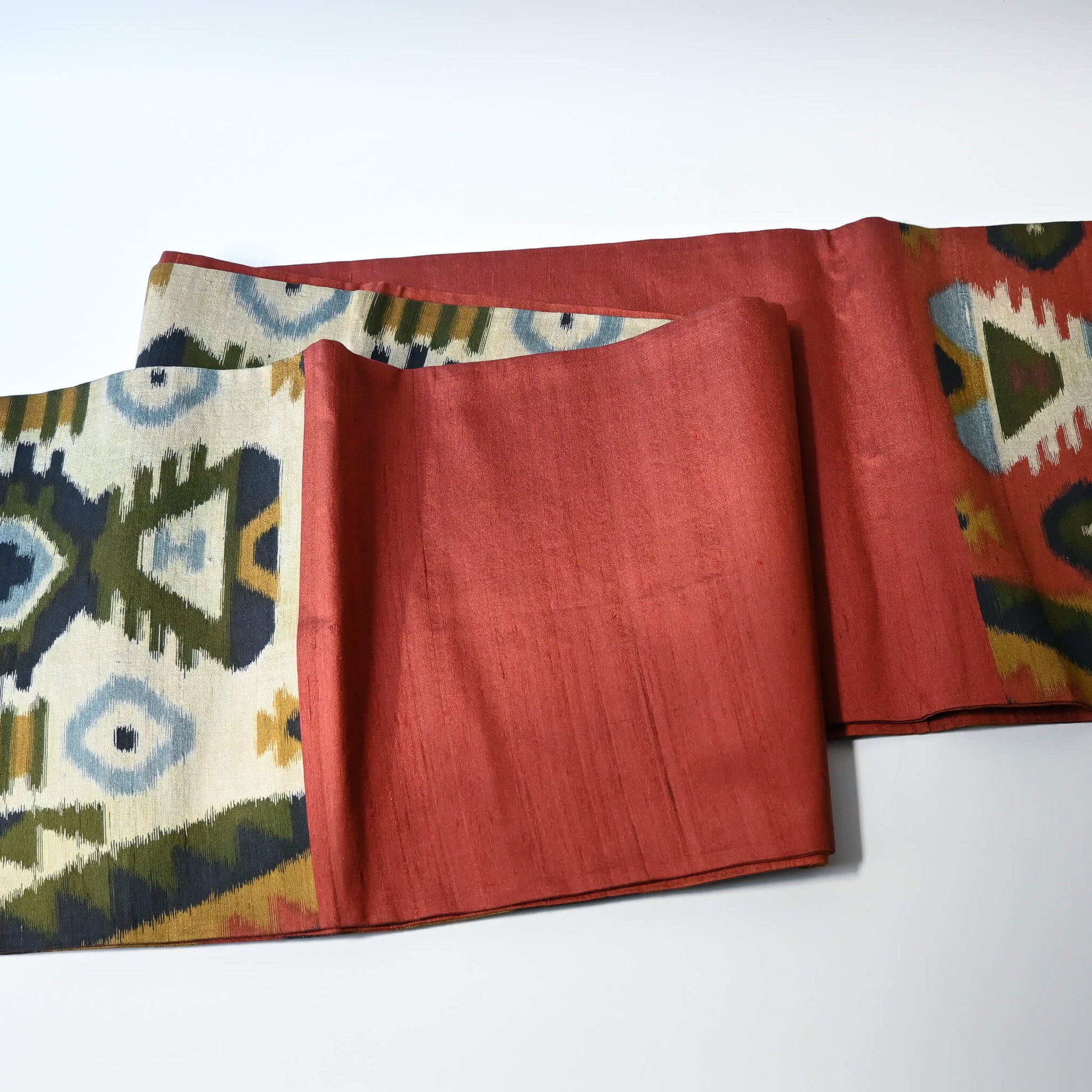 Detailed view of vintage Japanese women's tsumugi silk Fukuro obi with abstract geometric design in rustic orange and green tone.