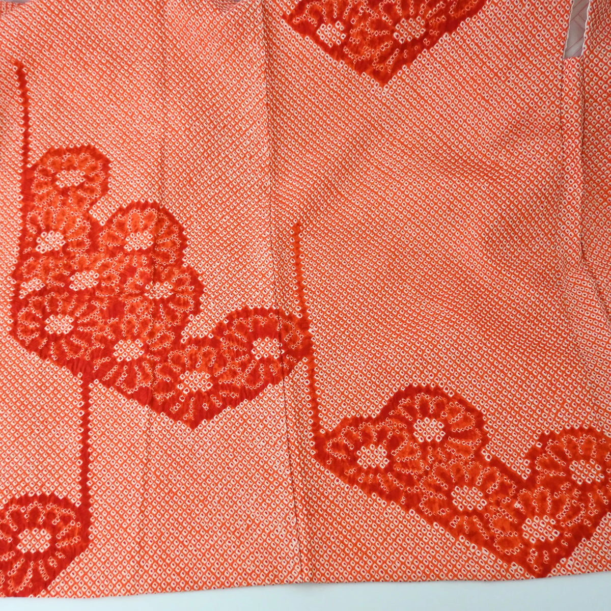 Back bodice of vintage Japanese women's orange silk shibori haori with chrysanthemum motif.