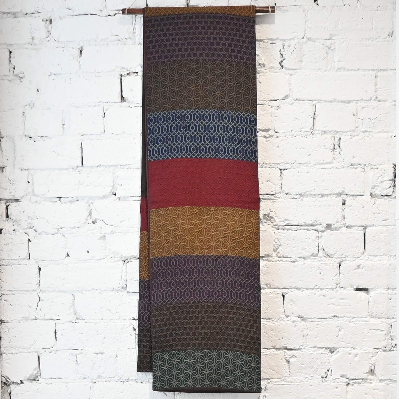 Hanging view of vintage Japanese women's silk textured geometric design Fukuro obi in warm rustic tones.