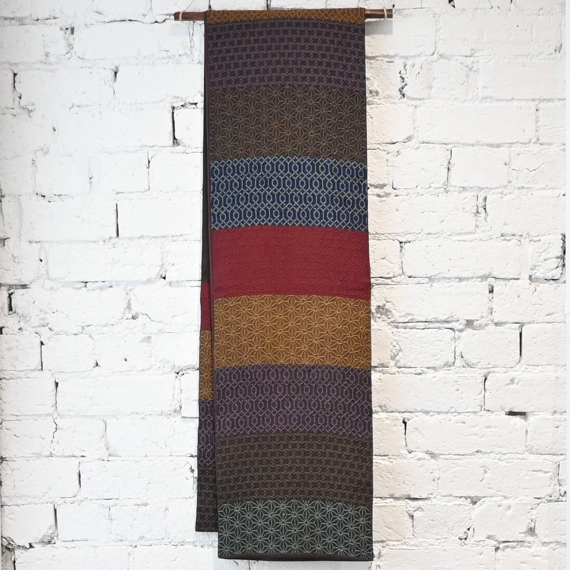 Hanging view of vintage Japanese women's silk textured geometric design Fukuro obi in warm rustic tones.