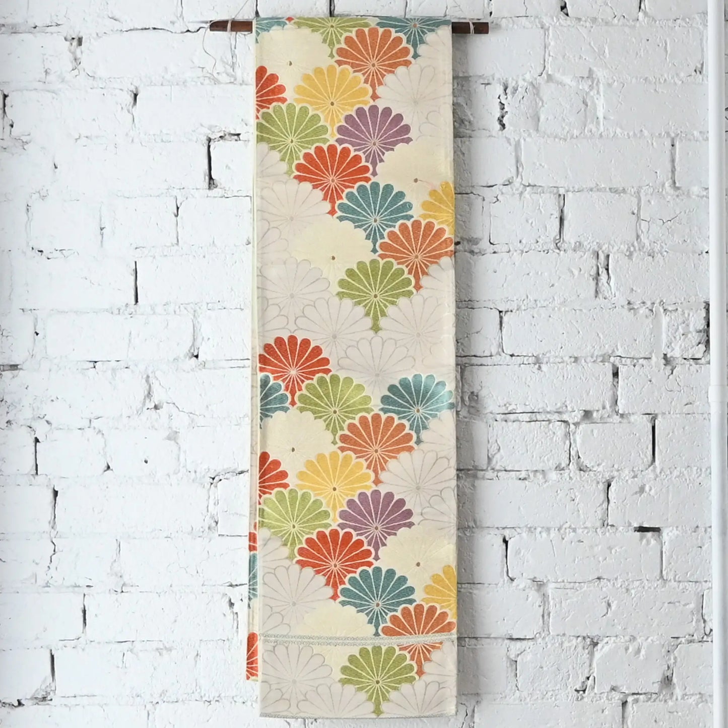 Hanging view of vintage women's white silk fukuro obi with colourful chrysanthemum motif.