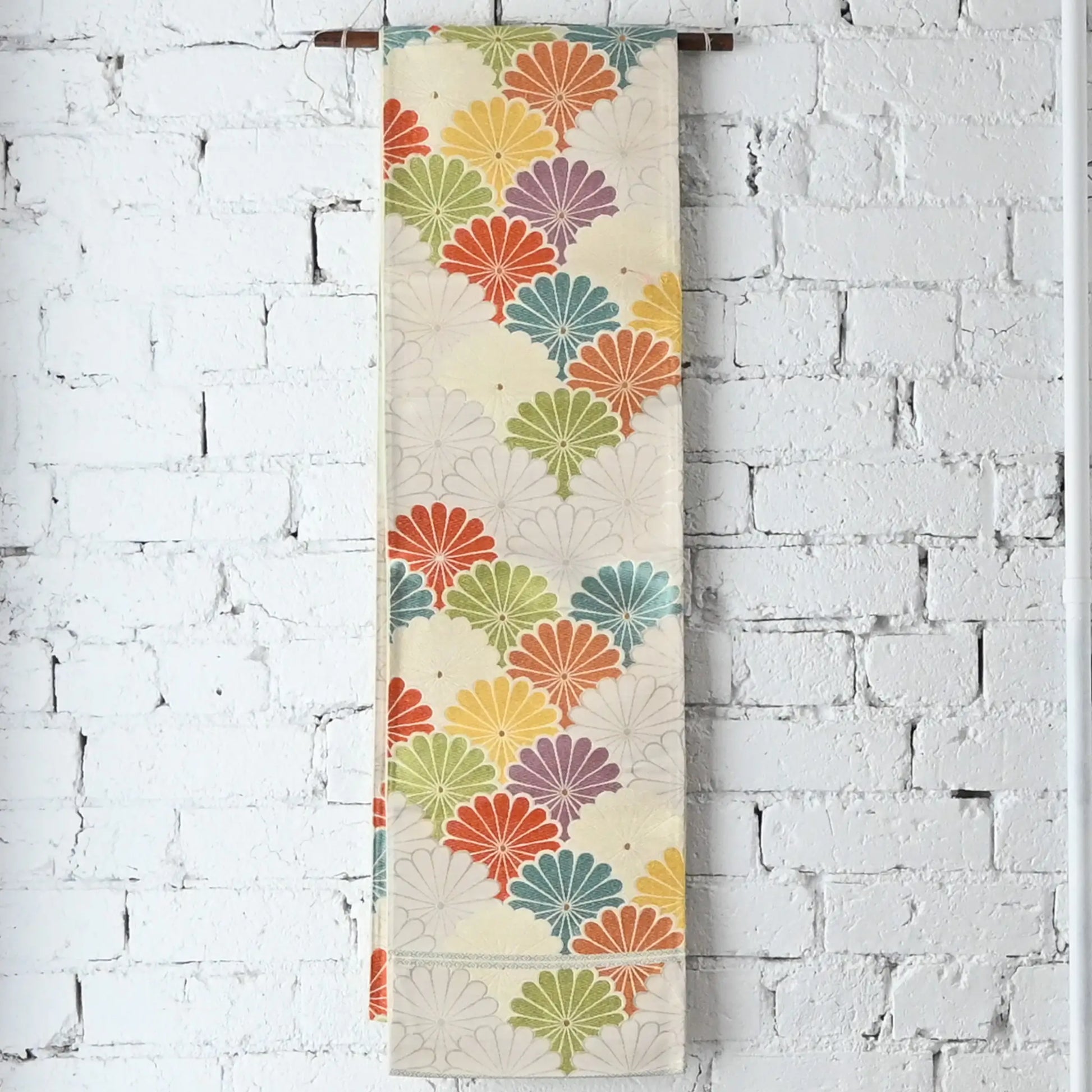 Hanging view of vintage women's white silk fukuro obi with colourful chrysanthemum motif.