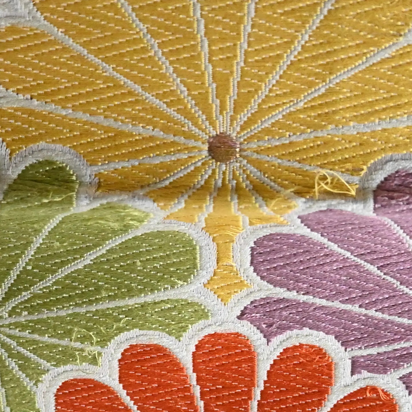 Close-up view of vintage women's white silk fukuro obi with colourful chrysanthemum motif.
