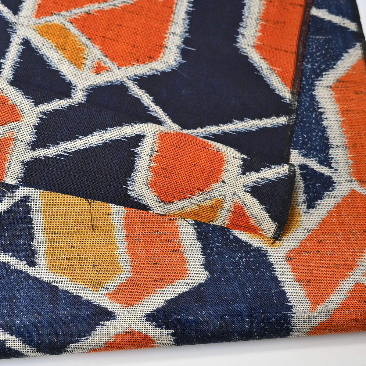 Detailed view of vintage wool kimono fabric in navy and orange with geometric modern pattern.