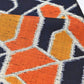Close-up view of vintage wool kimono fabric in navy and orange with geometric modern pattern.