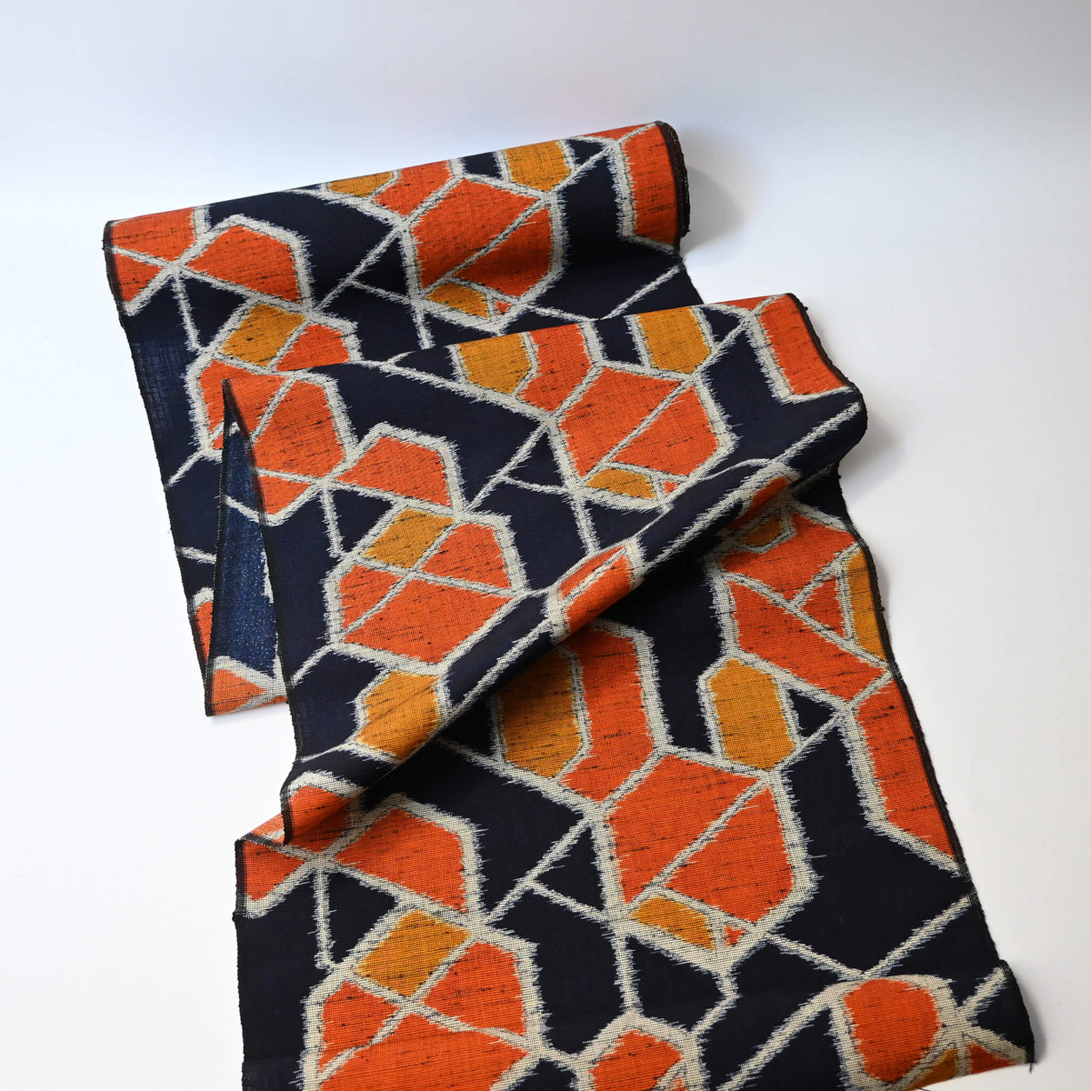 Vintage wool kimono fabric in navy and orange with geometric modern pattern.